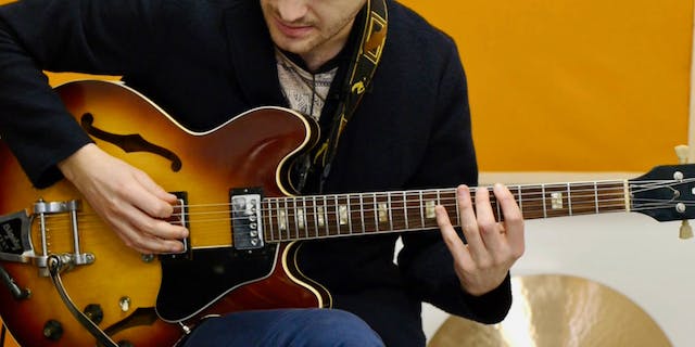 A Man Playing the Blues Scale on Guitar